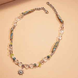 Gros plan du pendentif soleil en argent avec perles colorées et cordons de style ethnique