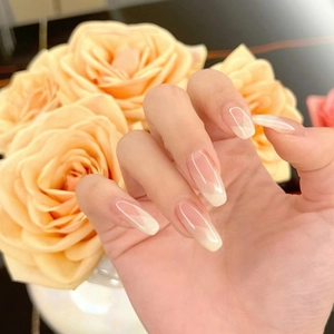 Detailed view of long coffin French gradient fake nails in nude pink and milky white
