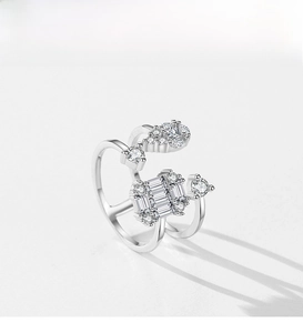 Macro shot of silver-colored layered geometric ring with radiant zirconia stone settings