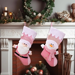 Close-up of pink Christmas stockings with Santa and snowman on a festive fireplace