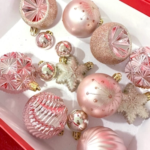 Pink and rose gold assorted Christmas ornaments set in a red gift box display