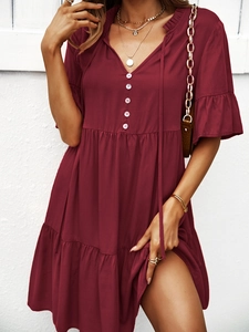 Détail de robe trapèze bordeaux avec boutons et manches courtes à volants