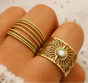 Detailed macro view of 18K gold plated hollow floral ring and multi-layer beaded ring band
