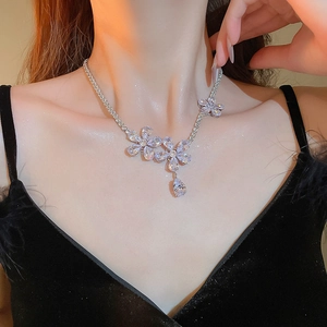 Close-up of elegant flower zircon necklace with teardrop pendant on female model