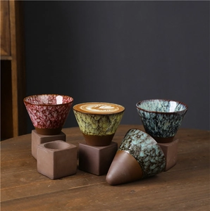 Detail of retro Japanese stoneware coffee mugs with unique glazed textures and conical base
