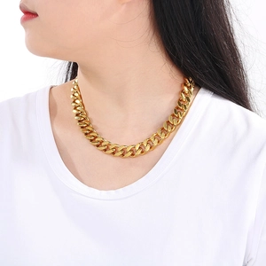 Close-up of a 13mm golden cuban link necklace worn by a female model in studio lighting
