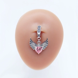 Gros plan d'un piercing nombril opale cœur rose avec ailes sur un modèle en silicone