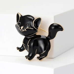 Detail of a vintage black enamel cat brooch with gold plating and sparkling black crystal eyes