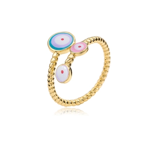 Macro view of gold plated evil eye ring with pink and purple enamel discs and spiral band