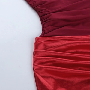 Détail d'une robe bordeaux montrant des textures de maille mate et de satin plissé
