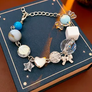 Chic multi-element beaded bracelet with bow, star, and candy charms on luxury gift box