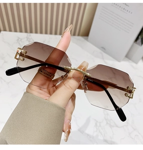 Detailed shot of rimless geometric sunglasses with brown gradient lenses and gold metal joints