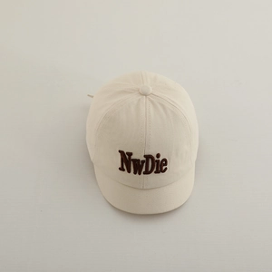 Detail of beige cotton baby baseball cap featuring brown 3D letter embroidery and top button