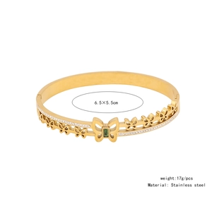 Detail view of gold stainless steel butterfly bracelet with green gemstone and micro-pave