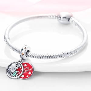 Macro detail of silver Christmas bracelet with reindeer, tree charms and Merry Christmas tag