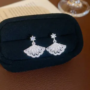 Exquisite silver fan-shaped drop earrings with clear zircon stones on black velvet box