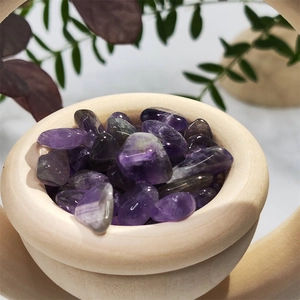 Macro shot of natural purple amethyst crystals inside a vertical wooden diffuser bowl