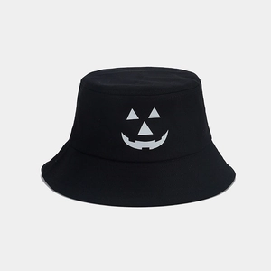 Detailed view of the white Jack-o'-lantern pumpkin face print on a black bucket hat