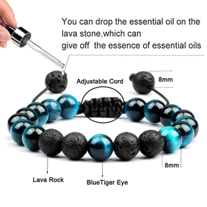Applying essential oil with a dropper onto 8mm lava rock beads of the tiger eye bracelet