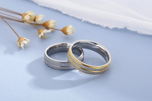 Macro detail of brushed stainless steel couple rings with silver and gold matte finish