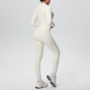 Dettaglio dei legging da yoga senza cuciture bianco crema e giacca sportiva con zip