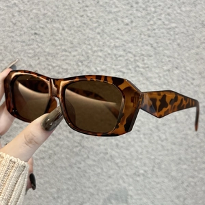 Detail of leopard print sunglasses featuring classic brown lenses and a retro rectangular frame