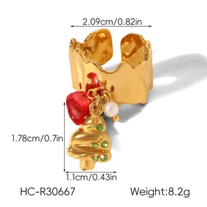 Detail of Christmas ring with green rhinestone tree and red heart pendant on gold band