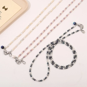 Detailed view of three beaded eyeglass chains with metal lobster clasps in soft colors