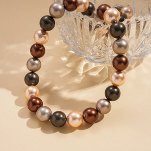 Collier bohème avec perles fantaisie multicolores sur un bol en verre texturé
