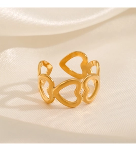 Detailed view of hollow heart ring in gold finish on soft satin background