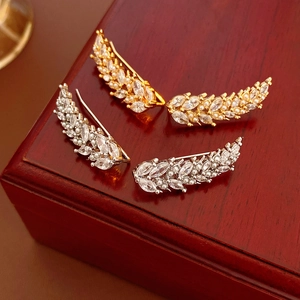 Detail of wheat ear earrings with zircon and pearls on a premium wood jewelry box