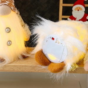 Detail of glowing Christmas gnome base with power switch and battery compartment