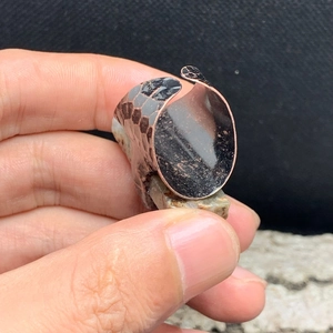 Macro shot of vintage style wide ring band featuring intricate embossed snake scale texture