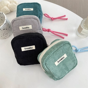 Close-up of colorful corduroy storage bags with zippers and bright contrast rope pulls