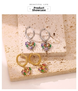 Détails de boucles d'oreilles cœur serties de zircons colorés en finitions or et argent