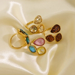 Luxuriöse vergoldete 14K Ringe mit bunten Kristallsteinen auf edlem Satin-Hintergrund