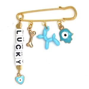 Detailed view of gold safety pin brooch with lucky beads, blue hamsa hand and evil eye charm