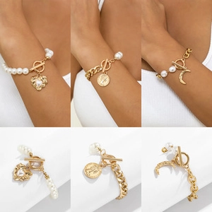 Detail of gold chain bracelets with pearls and heart, coin, and moon pendants using OT clasps