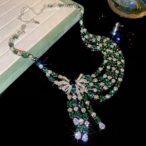 Bow necklace with emerald green gemstone and zircon tassels on silver chain