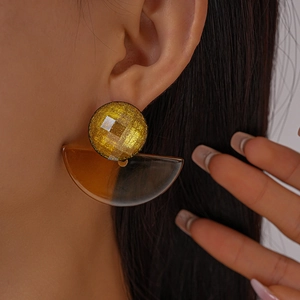 Close-up of geometric fan-shaped resin earrings with gold-toned faceted studs