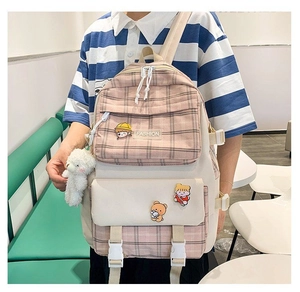 Pink checkered canvas backpack detail with cute plush bear pendant and cartoon badges