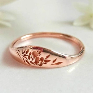 Elegant rose gold plated ring featuring intricate floral engraving and wavy band design