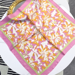 70cm square floral silk scarf in pink and yellow flowers on a white elegant table