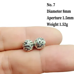 Detailed macro of 8mm silver lantern spacer bead with vintage floral relief textures