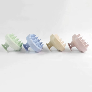 Detail of four wheat straw scalp massage brushes in Morandi colors with ergonomic handles