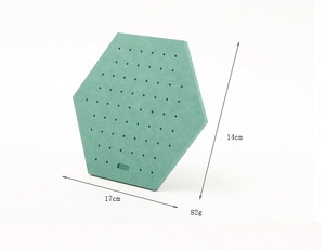 Detail of green hexagonal jewelry display base with hole patterns showing 17x14cm size