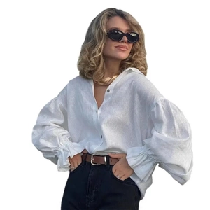 Detail of white cotton linen shirt showing lantern sleeves and high-quality button closure
