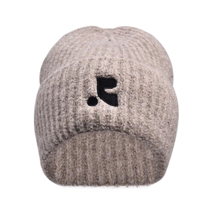 Detailed macro of thick rib-knit texture and minimal black puppy embroidery on beige beanie