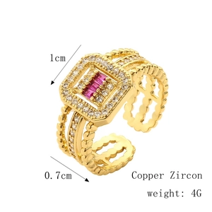Detail of vintage gold-plated copper ring with white zircon and red baguette stones