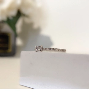 Macro shot of silver square emerald cut zircon ring with micro-pave diamonds detail